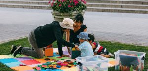 Family enjoying art projects on lawn in Kendall Square